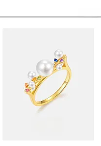 Détail macro de la bague en or 10k avec perle blanche et oxydes de zirconium arc-en-ciel