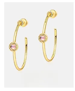 Detail of S925 silver bangles with pink stones and sparkling halo in golden finish