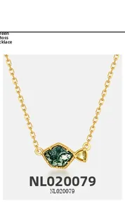 Detail of irregular green moss agate pendant with yellow gemstone on 18K gold chain