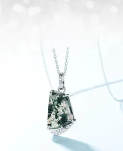 Detail of green moss agate pendant with natural inclusions and silver prong setting