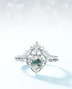 Macro view of pear-shaped moss agate ring set with sparkling side diamonds in silver