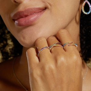 Macro detail of S925 silver double-row cross ring and earrings with rainbow cubic zirconia