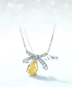Detail of S925 silver bow necklace featuring a large yellow teardrop-cut gemstone pendant
