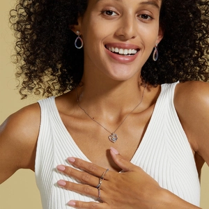Modèle portant collier cœur et boucles d'oreilles en argent S925 avec gemmes arc-en-ciel