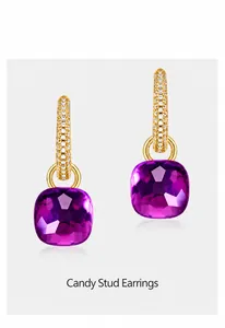 Detail of candy-style earrings with pave-set crystals and a faceted purple gemstone