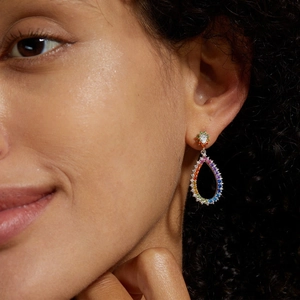 Macro view of rainbow zircon teardrop earrings in S925 silver on a model's ear