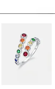 Détail d'une bague argentée ouverte ornée de zircons multicolores sertis en clos