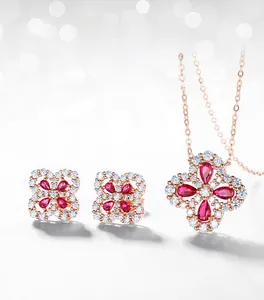 Detail of rose gold clover jewelry set with red pear-cut stones and pave zircons