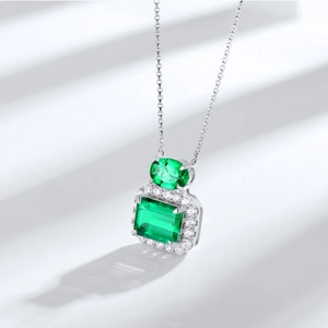 Collier classique en argent S925 avec deux pierres émeraude et halo de diamants sur blanc