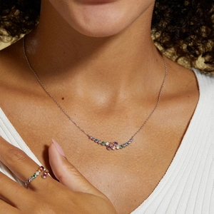 Close-up of S925 silver rainbow gemstone necklace and matching open ring on a model