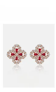 Macro shot of rose gold four-leaf clover earrings with red stones and pavé crystals