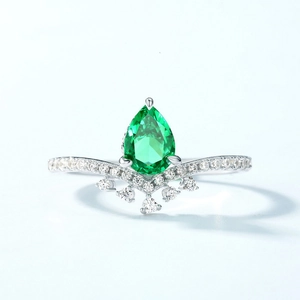 Elegant pear cut emerald green stone ring with V-shaped silver crown and cubic zirconia