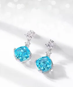 Macro view of S925 silver earrings with ice-cut sea blue zircon and square accents