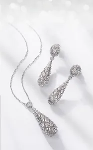 Detail view of retro lace hollow silver earrings set with sparkling white cubic zirconia