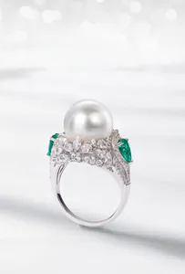 Macro shot of large white shell pearl ring with green marquise stones and silver band