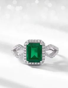 Macro detail of emerald-cut lab emerald ring with sparkling pave cubic zirconia accents