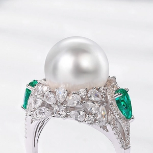 Luxurious S925 silver ring featuring a large white pearl and green emerald-cut stones