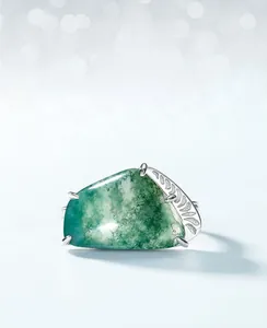 Macro view of moss agate ring with silver leaf relief pattern and natural green textures