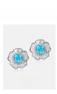 Macro view of flower-shaped silver stud earrings with blue high-carbon diamond center
