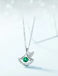 Vue macro d'un pendentif feuille de ginkgo en argent S925 avec émeraude et zircon