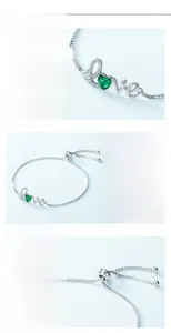 Close-up of S925 silver love bracelet featuring a green heart gemstone and fine plating
