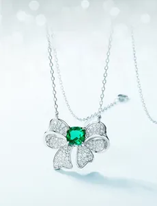 Detailed close-up of emerald butterfly pendant necklace with white cubic zirconia accents