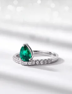 Macro shot of pear-cut lab emerald ring in S925 silver with white zircon side stones