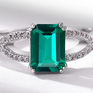Vintage emerald-cut green gemstone ring with silver twisted band and pavé diamonds