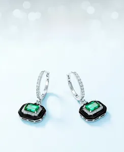 Detail of S925 silver stamp on emerald earrings with black enamel and white zircon border