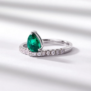 Elegant S925 silver pear cut emerald ring with pavé accent stones on white background