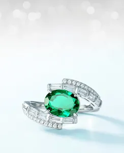 Macro shot of oval lab-grown emerald ring with zircon halo and silver finish