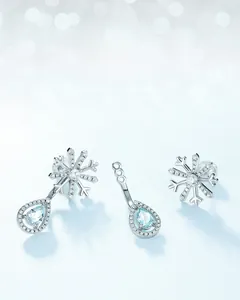 Detail of S925 silver snowflake earrings with sky blue topaz and sparkling zircons