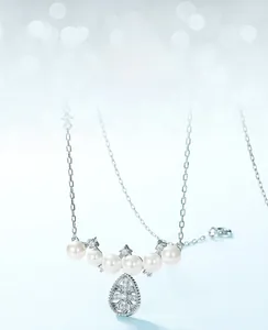 Detailed macro of snowflake pendant necklace with five shell pearls and silver chain