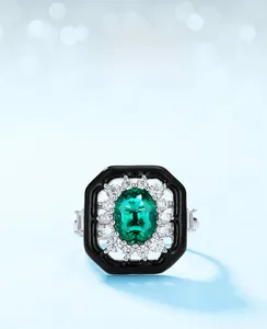 Macro detail of retro sunflower ring with emerald main stone and black enamel frame