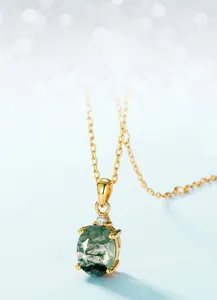 Macro shot of oval green moss agate pendant with 18K gold chain on blue background
