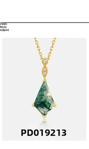 Macro shot of kite-cut moss agate pendant in gold-plated prong setting with small diamonds