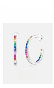 Detailed close-up of C-shaped silver earrings with multi-color rainbow cubic zirconia