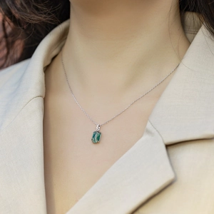 Natural green moss agate rectangular pendant on silver chain worn by a model