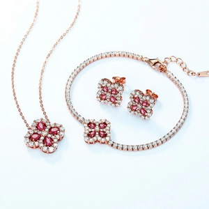 Set gioielli trifoglio in oro rosa con pietre preziose rosse e cristalli lucenti