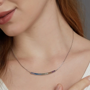 Elegant S925 silver necklace with a curved rainbow zircon pendant on model neckline