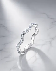 Macro di anello a fascia ondulata in argento con micro-pavé su uno sfondo minimalista