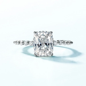 Bague en argent S925 avec Moissanite taille coussin et pierres latérales sur fond bleu
