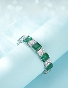 Macro detail of S925 silver bracelet featuring emerald-cut green gems and white zircons