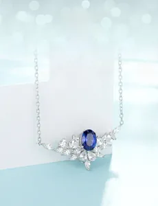 Macro shot of silver emerald cut necklace with blue oval stone and white zircon stones