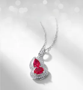Detailed view of silver gourd pendant featuring red gemstones and white cubic zirconia