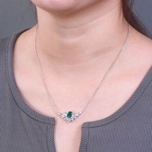 Elegant S925 silver necklace with emerald pendant and floral halo on a female model
