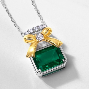 French luxury perfume bottle necklace with emerald pendant and golden bowknot detail