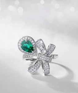 Detailed macro view of bow-knot emerald ring with pear-cut stone and diamond accents