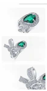 Macro shot of S925 silver bow ring with pear-cut emerald and micro-paved diamonds