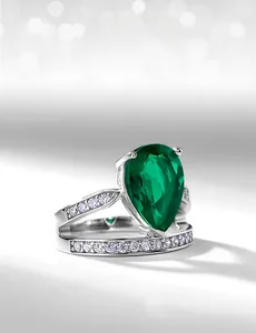 Macro shot of pear-cut emerald ring with s925 silver split shank and zircon accents